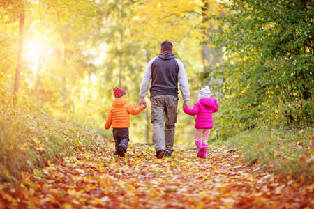 boy and girl with father holding hands on the natureの写真素材