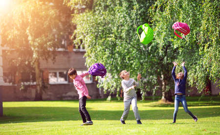 Children with rucksacks standing in the park near schoolの写真素材