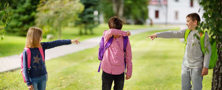 Children with rucksacks standing in the park near schoolの写真素材