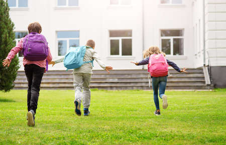 Children with rucksacks standing in the park near schoolの写真素材