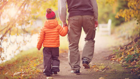 Child standing with umbrella in beautiful autumnal dayの写真素材