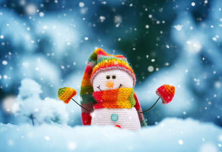 little snowman on soft snow on blue backgroundの写真素材