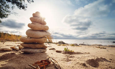 zen stones stacked at sea with backlightの写真素材