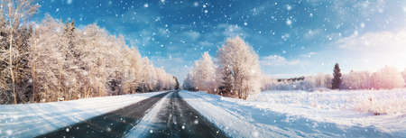 winter road, covered with snow on sunny day. Black icy asphaltの写真素材