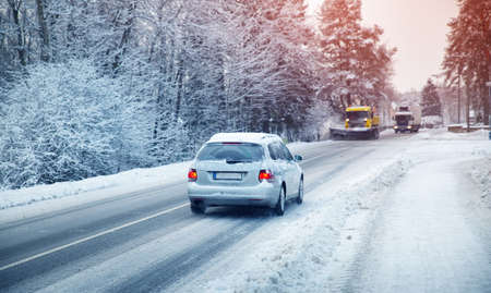 Car tires on winter road covered with snow.の写真素材