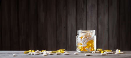 Pills in a jar on wooden backgroundの写真素材