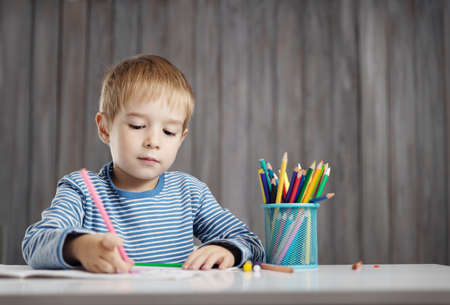 Little child at home drawing on the paper