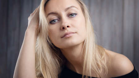 Happy beautiful young blond woman portrait with wooden background