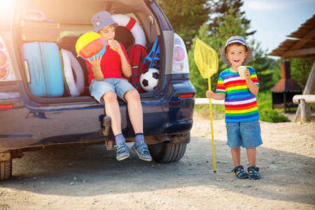 child sitting in car filled with traveling accessoriesの写真素材