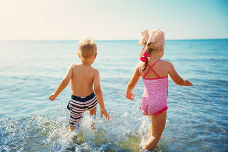 Boy and girl playing on the beachの写真素材