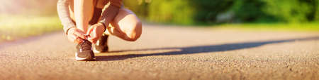 Young woman running in the park on asphalt road