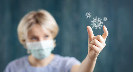 young woman in medical face protection mask indoors on blue background