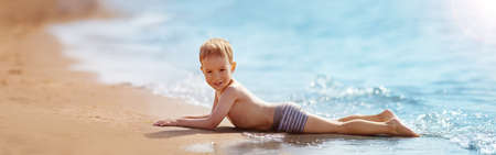 Boy lying on the beach at sea in summer