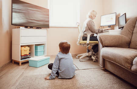 woman working at home with little child.の写真素材