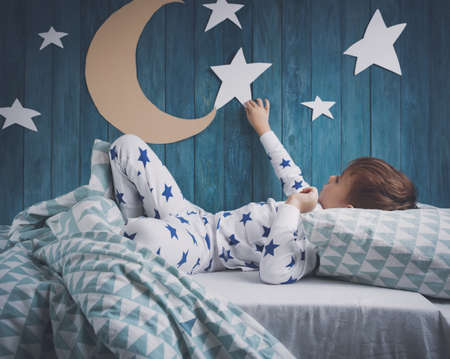 Five years old child sleeping in bedの写真素材