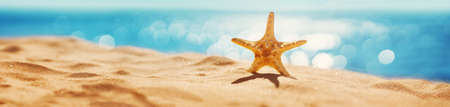 Blurred sea background with beautiful bokeh and sand on foreground