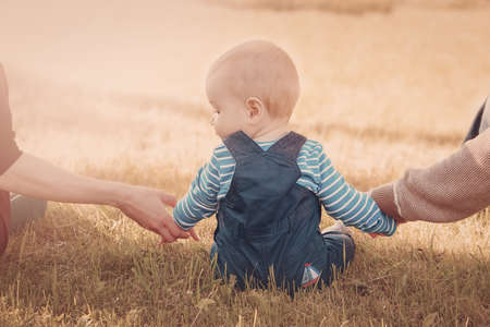 Baby with mother and father holding handsの写真素材