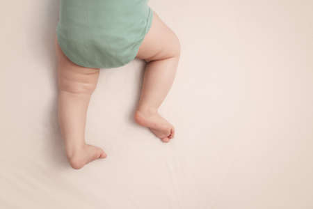 sleeping baby feet on white background in bedの写真素材