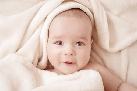 Baby boy sleeping covered with soft blanketの写真素材