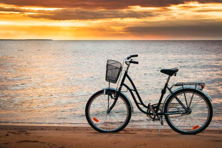 Lonely bike standing at sunset at seasideの写真素材