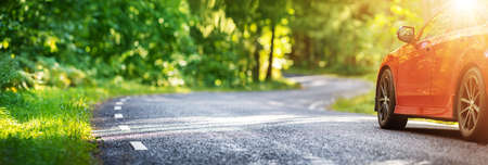red car on asphalt road in summerの写真素材