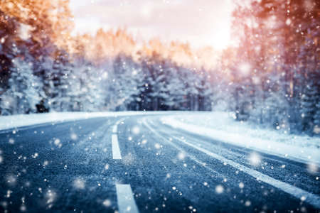 winter road, covered with snow on sunny day. Black icy asphaltの写真素材