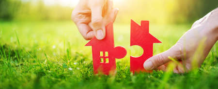 Model of small red house in the human hand. Concept of funding, buying, selling and renting.の写真素材