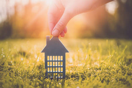 Model of gray apartment house on autumn yellow grass on a sunny day. Conceptual symbol of renting, hostel and student housing.の写真素材