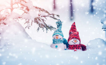 little knitted snowmans on soft snow on blue backgroundの写真素材