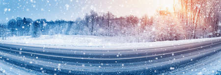Panorama of the winter road covered with snow in snowfall. Beautiful trees at the edges of the road.の写真素材