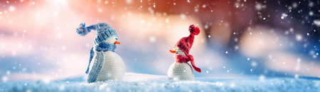 Little knitted snowmen on soft snow on blue backgroundの写真素材