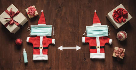Santa clothes with a medical face mask on brown wooden background