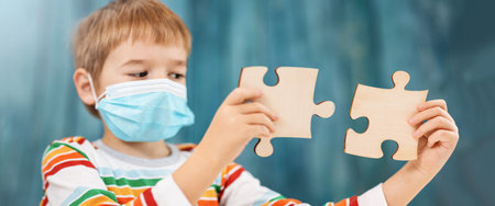 Boy in medical face protection mask indoors on blue background.の写真素材
