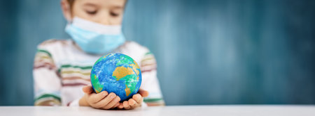 Boy in medical face protection mask indoors on blue backgroundの写真素材