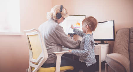 Woman working at home with little child.の写真素材