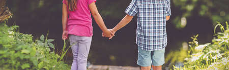 Girl and boy standing together in the park.の写真素材
