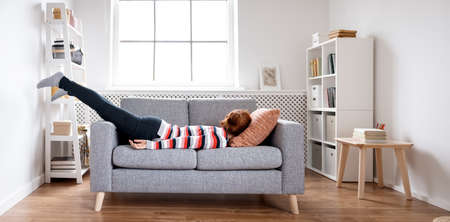 Tired woman lying on the sofa after hard day.の写真素材