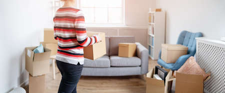 Woman carrying cardboard box in her hands
