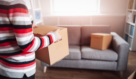 Woman carrying cardboard box in her handsの写真素材