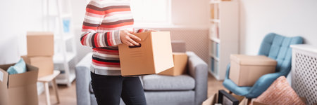 Woman carrying cardboard box in her handsの写真素材