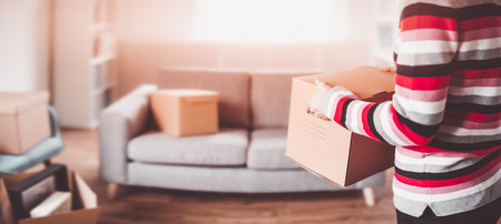 Woman carrying cardboard box in her handsの写真素材