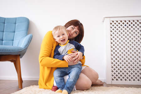 Young mother embracing her cute son carefullyの写真素材