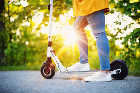Woman riding on scooter in park in summer. Urban eco transportationの写真素材