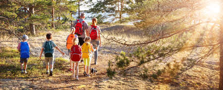 Big family with backpacks on the nature near the seaの写真素材