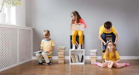 Group of children sitting in the room and reading books.の写真素材
