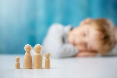 Child with wooden figures of the family on the blue backgroundの写真素材