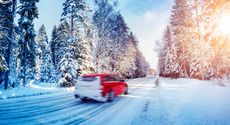 Beautiful snowy country road in winter with cars on it.の写真素材