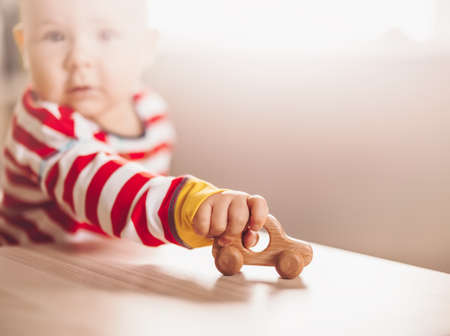 Little boy playing with wood car indoorの写真素材