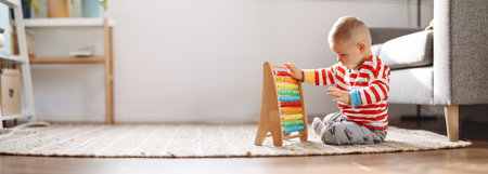 Cute child sitting on the floor in the room and playing with toys.の写真素材
