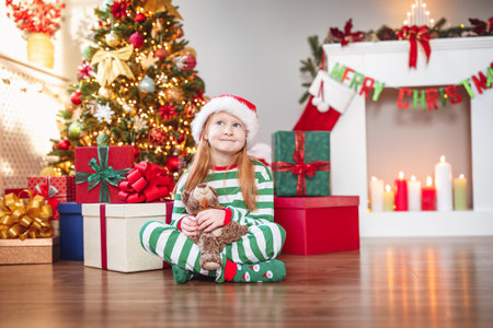 Cute little girl sitting in the room with christmas decorationの写真素材